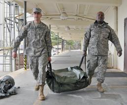 Army Spcs. Adam Schroeder (left) and Bernard Satchell, both with the Georgia National Guard�s 124th Mobile Public Affairs Detachment, preposition the unit�s tents to house unit members should they be called out to assist during the storm expected to hit Georgia today.
